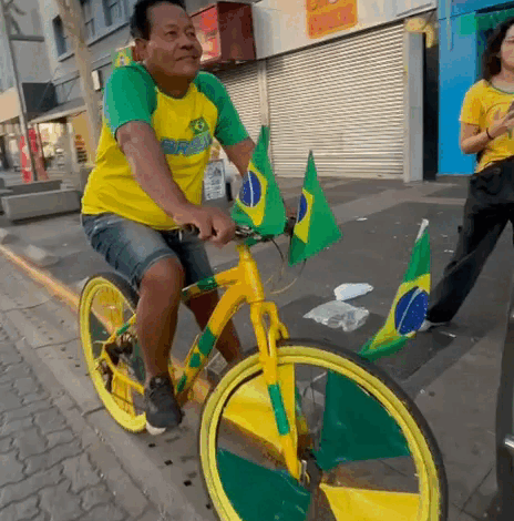 Pintor atrai olhares com bicicleta verde e amarela na Copa